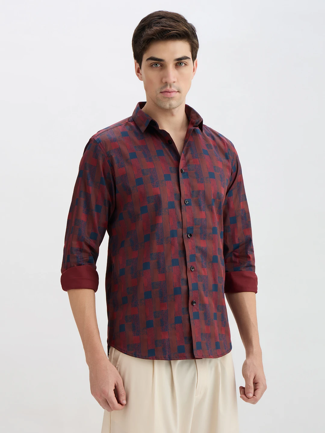 Three-quarter front pose showing button placket and all-over navy block pattern