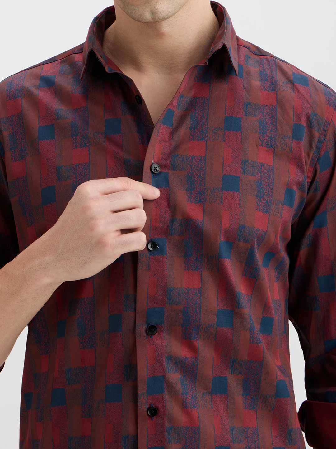 Close-up of collar, black buttons, and textured maroon and navy geometric print