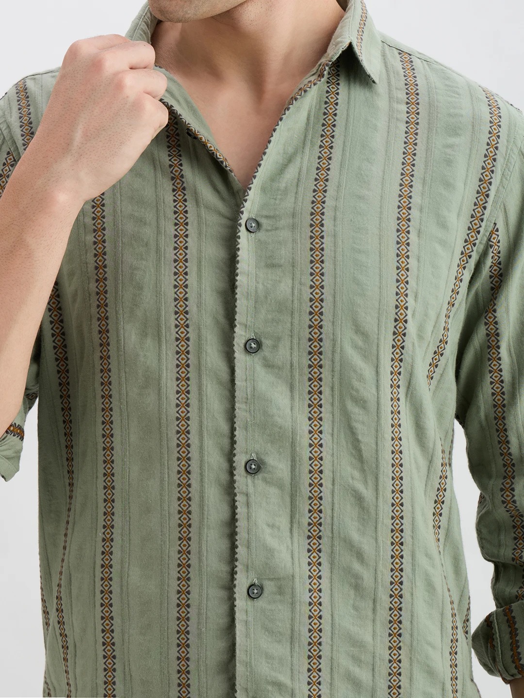 Close-up of collar, buttons, and vertical printed stripe detail on the sage green fabric