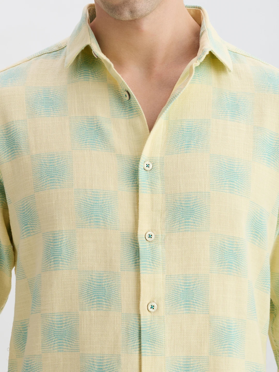Close-up of collar, buttons and yellow-mint check fabric texture