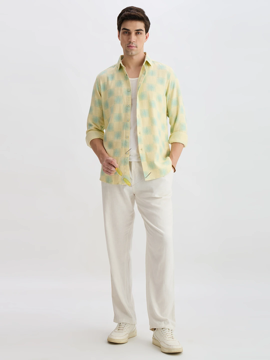 Full-length styling view with the checked shirt worn open over a white inner