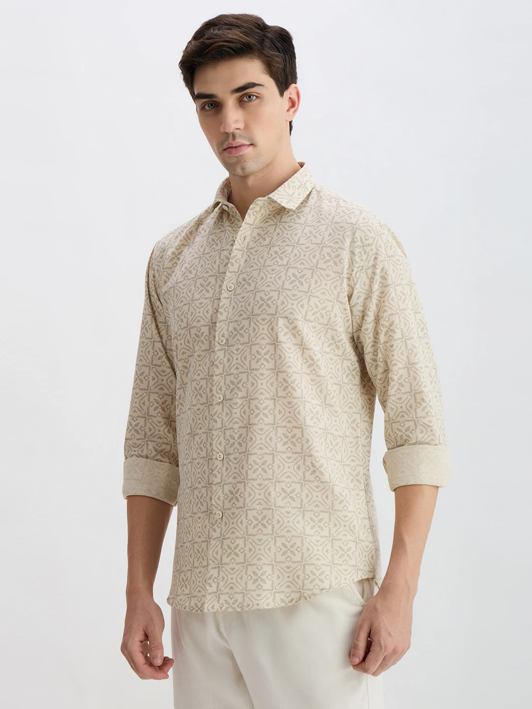 Three-quarter front view with sleeves rolled up, showing beige printed shirt and spread collar