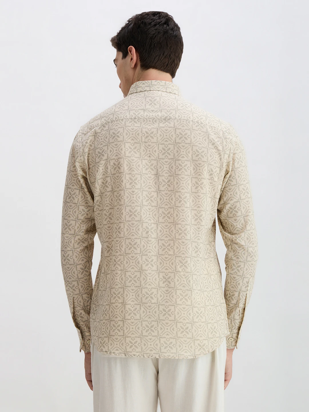 Back view of the beige printed shirt showing full all-over pattern and curved hem