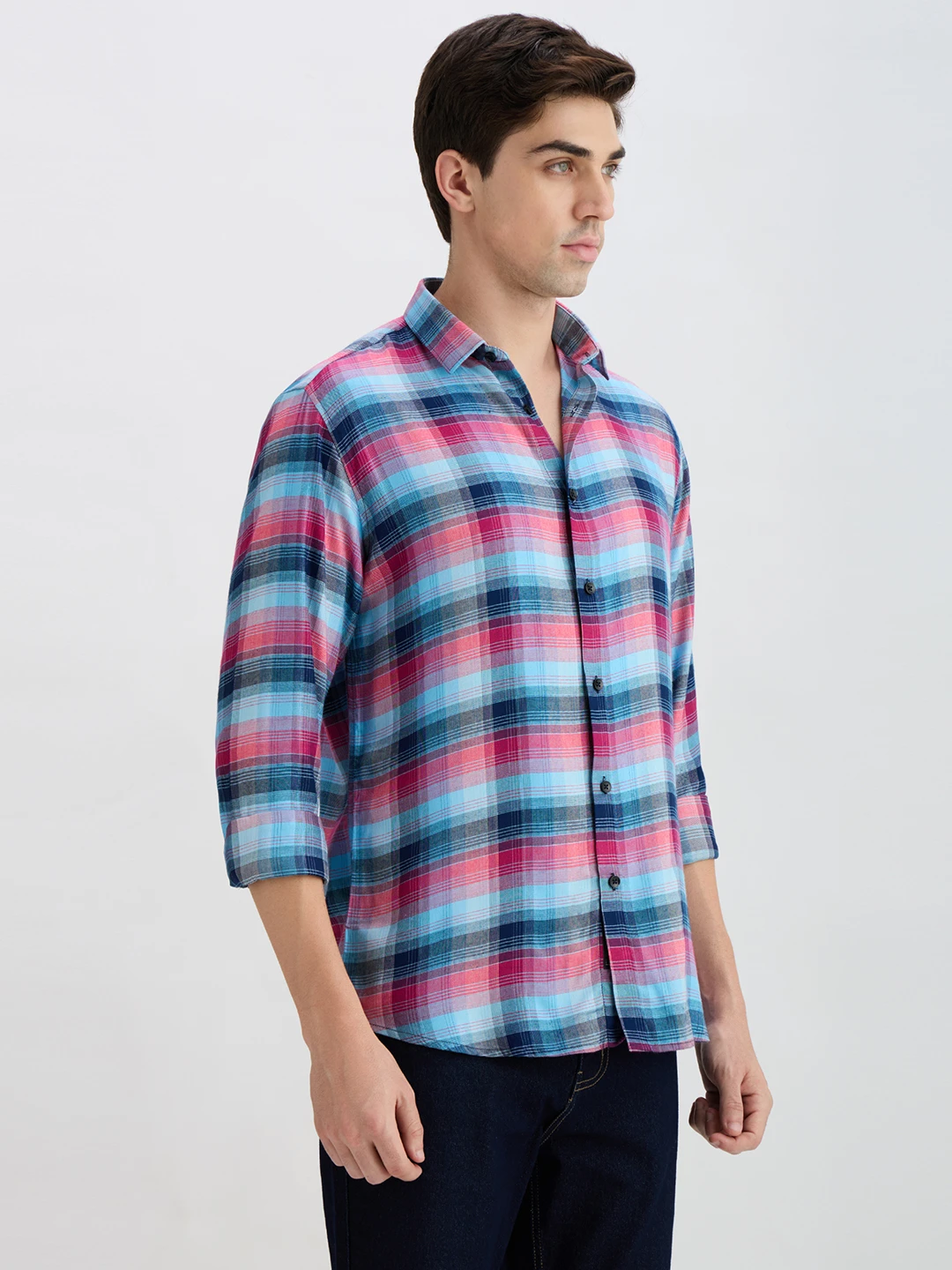Side profile view of the shirt highlighting the curved hem and rolled long sleeves