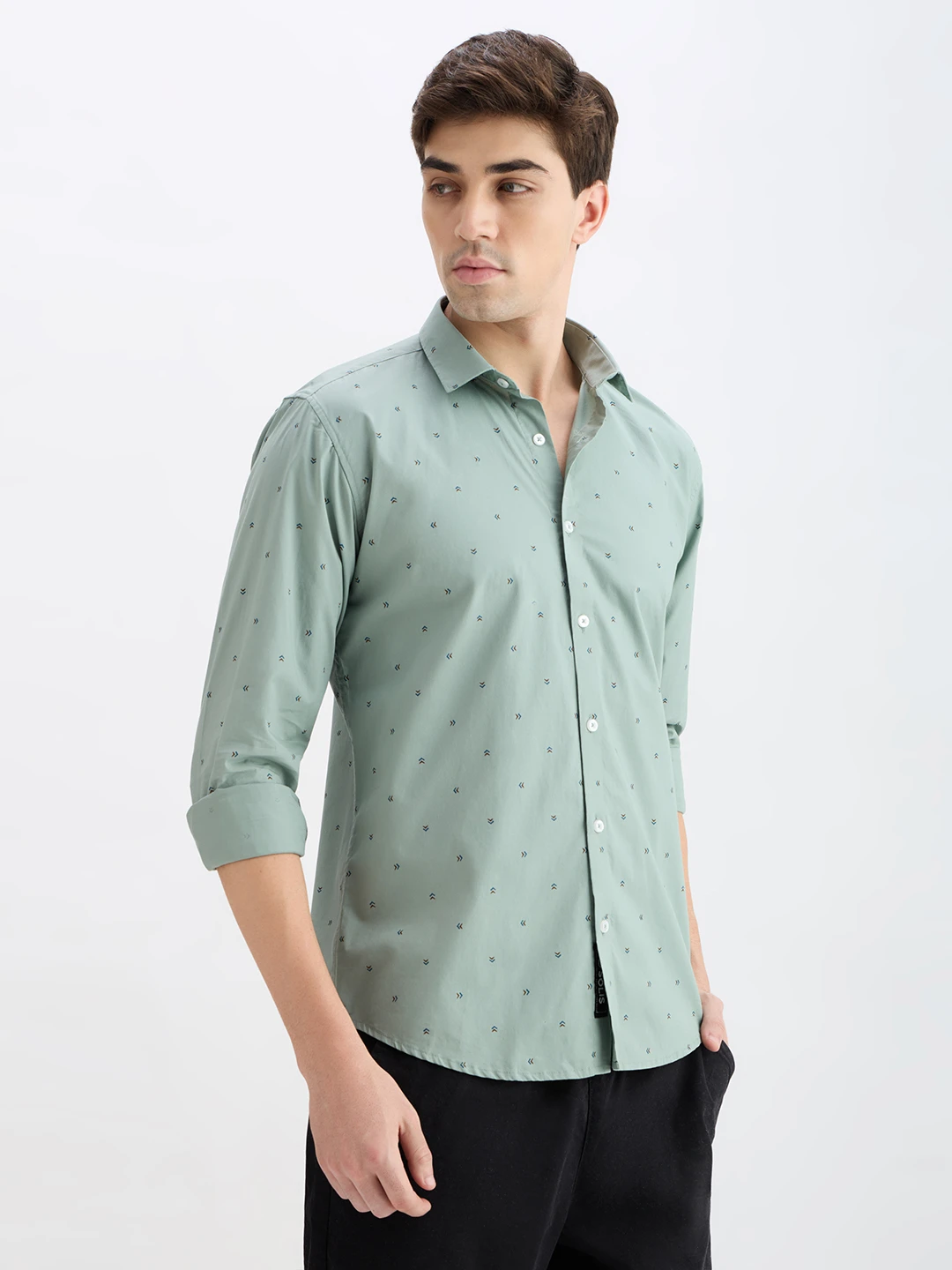 Side-front view of the shirt highlighting curved hem and rolled long sleeves