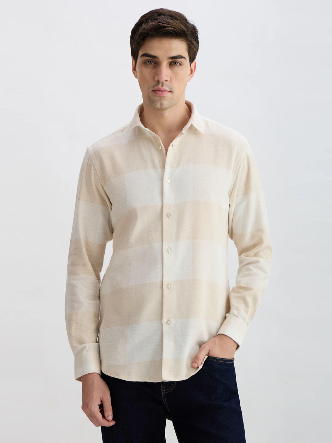 Front view of the cream long sleeve shirt with subtle large check pattern and button placket