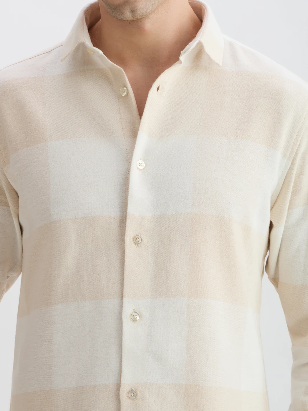 Close-up of the collar, buttons, and soft checked fabric texture on the chest