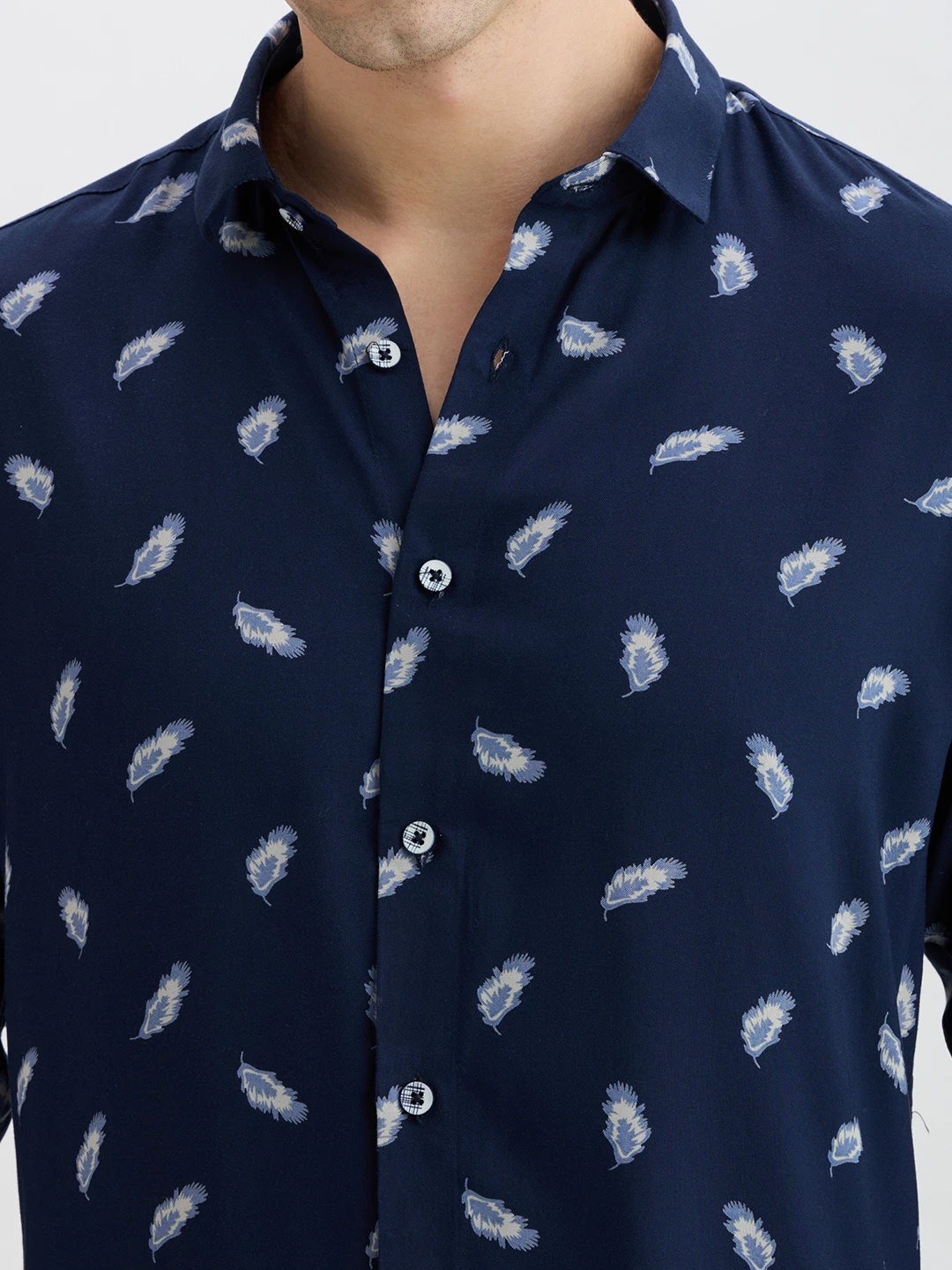 Close-up of collar, buttons and feather motif on the navy fabric
