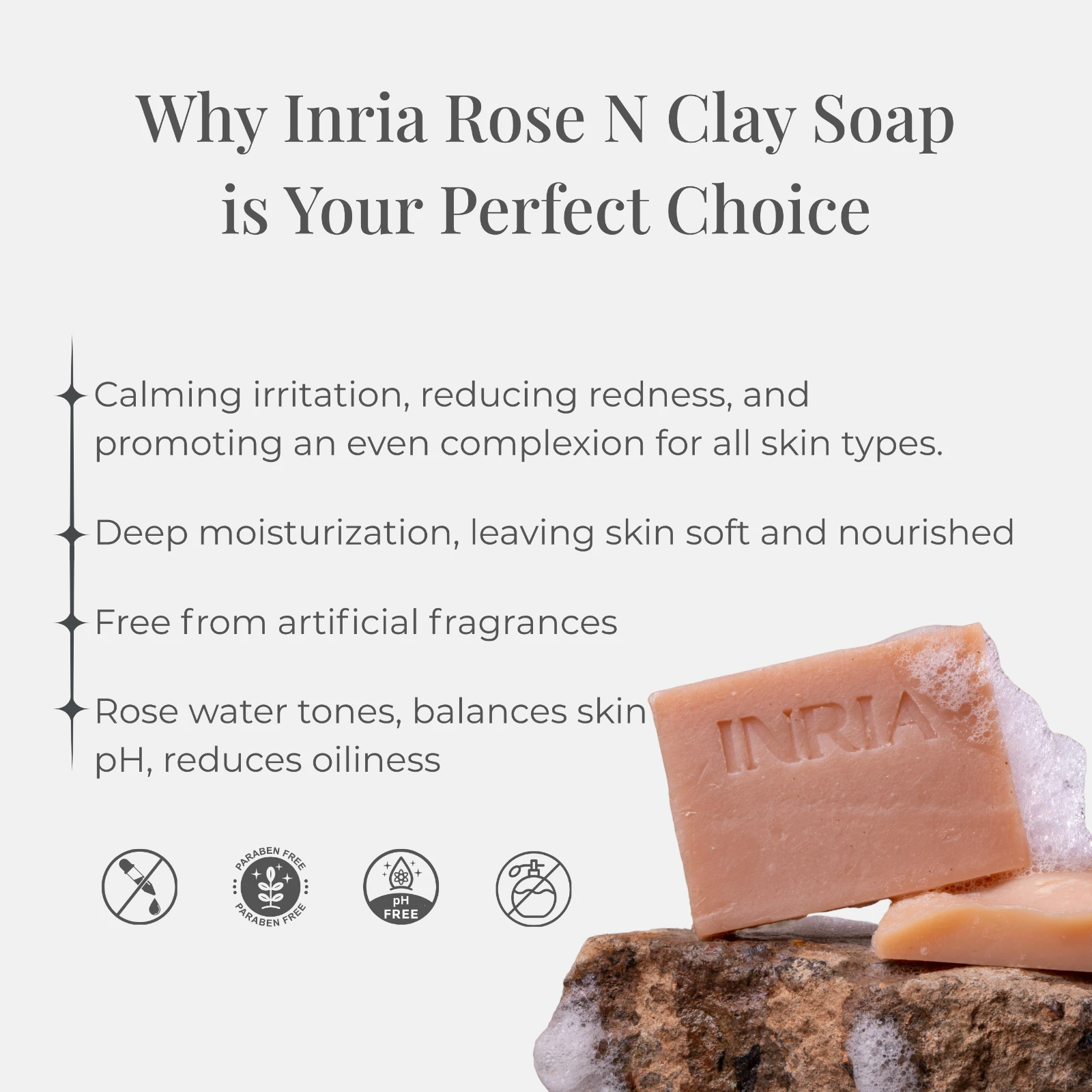 Benefit infographic for Inria Rose N Clay Soap with skin-calming claims, ingredient-free icons, and sudsy soap bars on stone