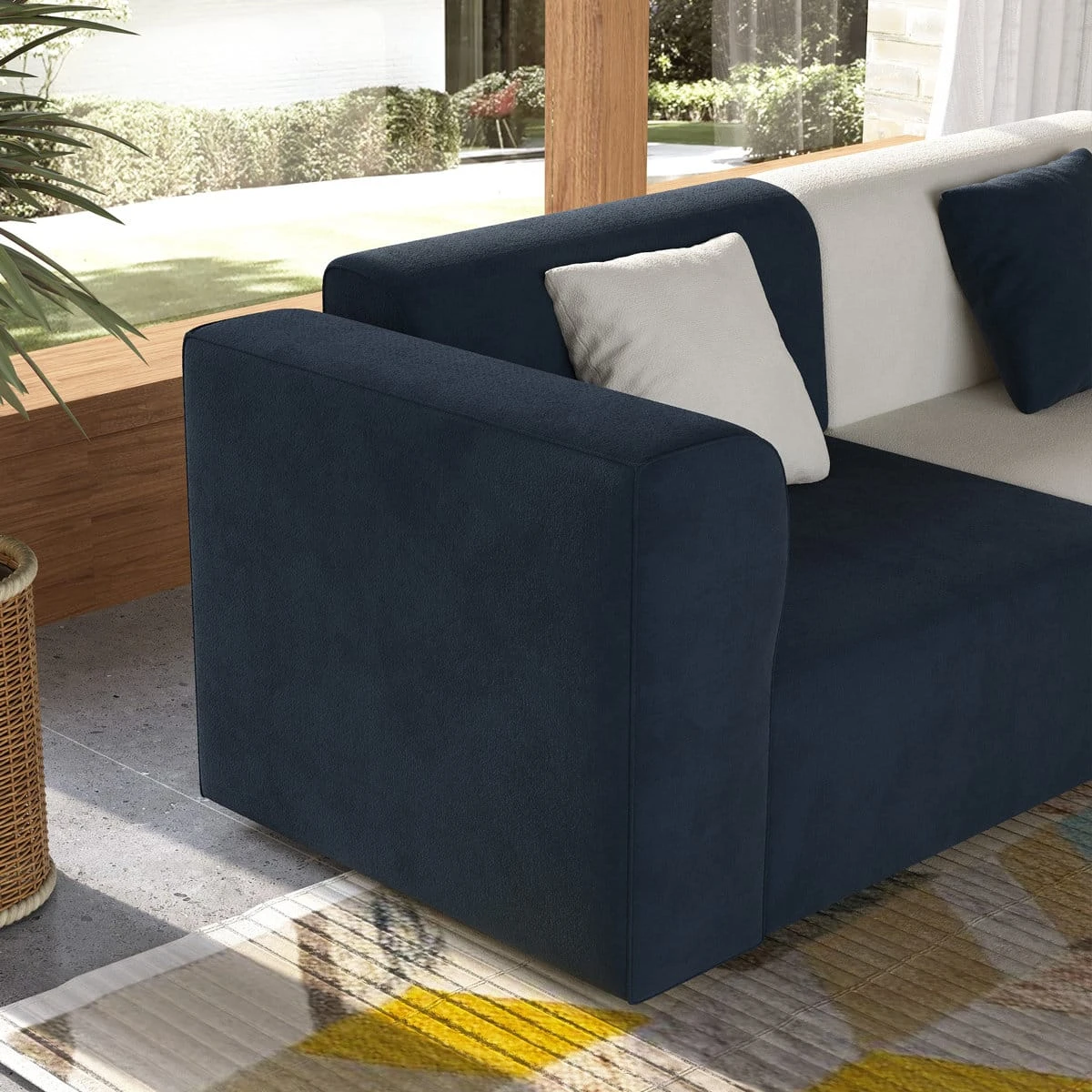 Close-up of the left armrest and navy seat section with white accent cushion
