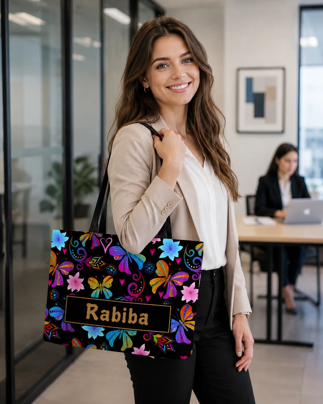 Personalized butterfly tote carried in office setting, with name Rabiba on gold-bordered black label