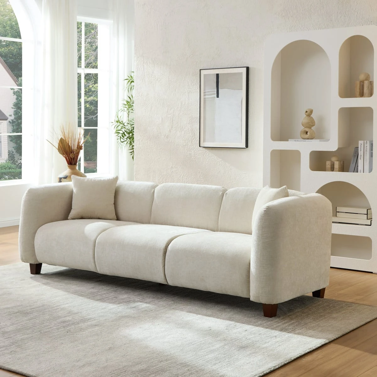 Angled left-front view showing rounded arms, textured upholstery and dark wooden legs