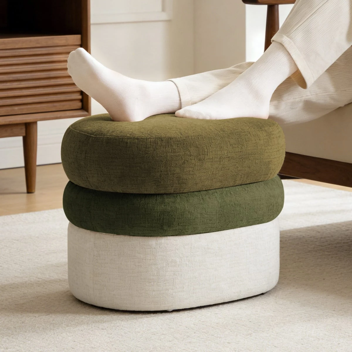 Close lifestyle view showing feet resting on the cushioned olive top of the ottoman