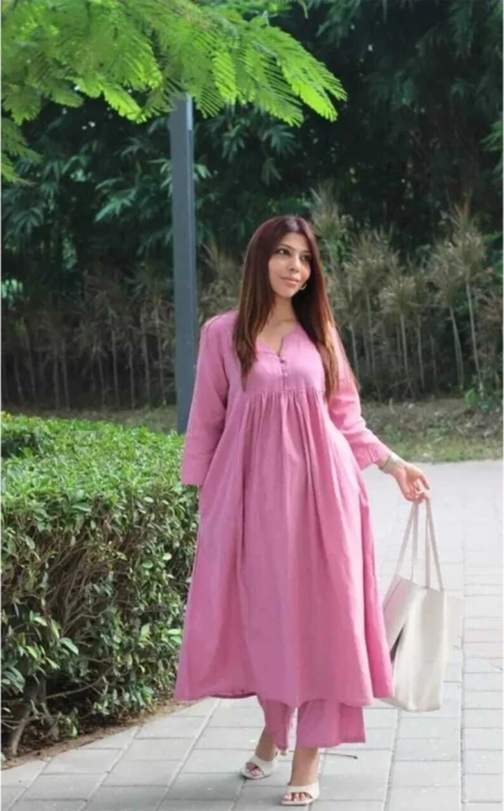 Angled outdoor view of the pink kurta set showing its flared silhouette and ankle-length palazzos