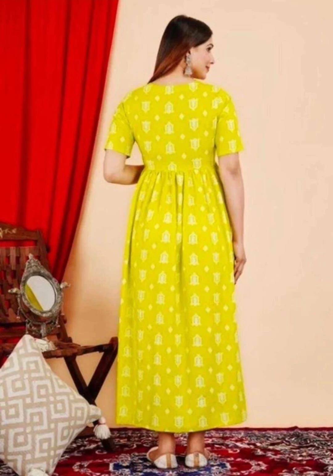 Sleeveless yellow printed maxi dress with tiered flared hem shown in a full-length outdoor front view