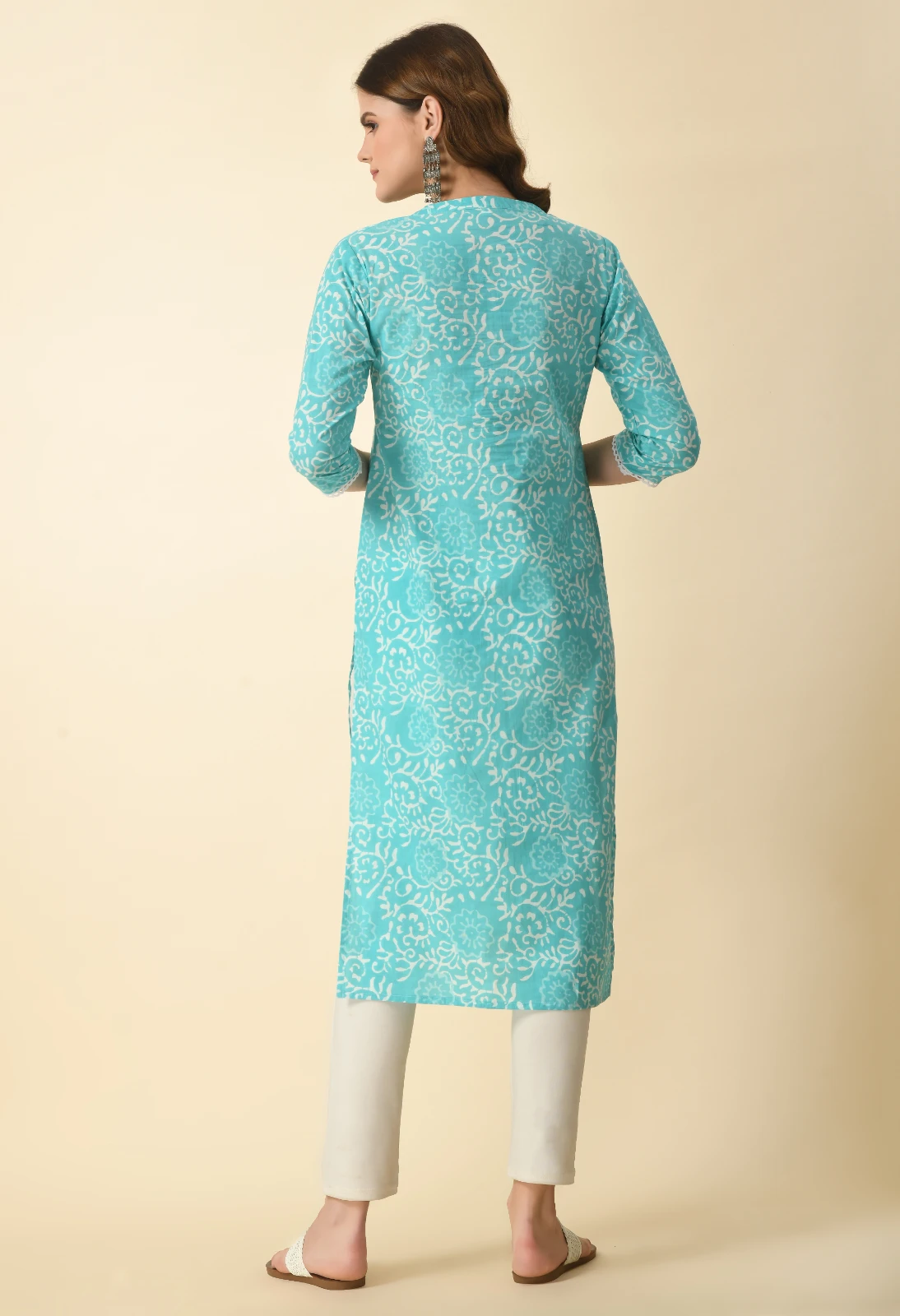 Back view of turquoise floral print kurta with three-quarter sleeves, paired with white ankle pants