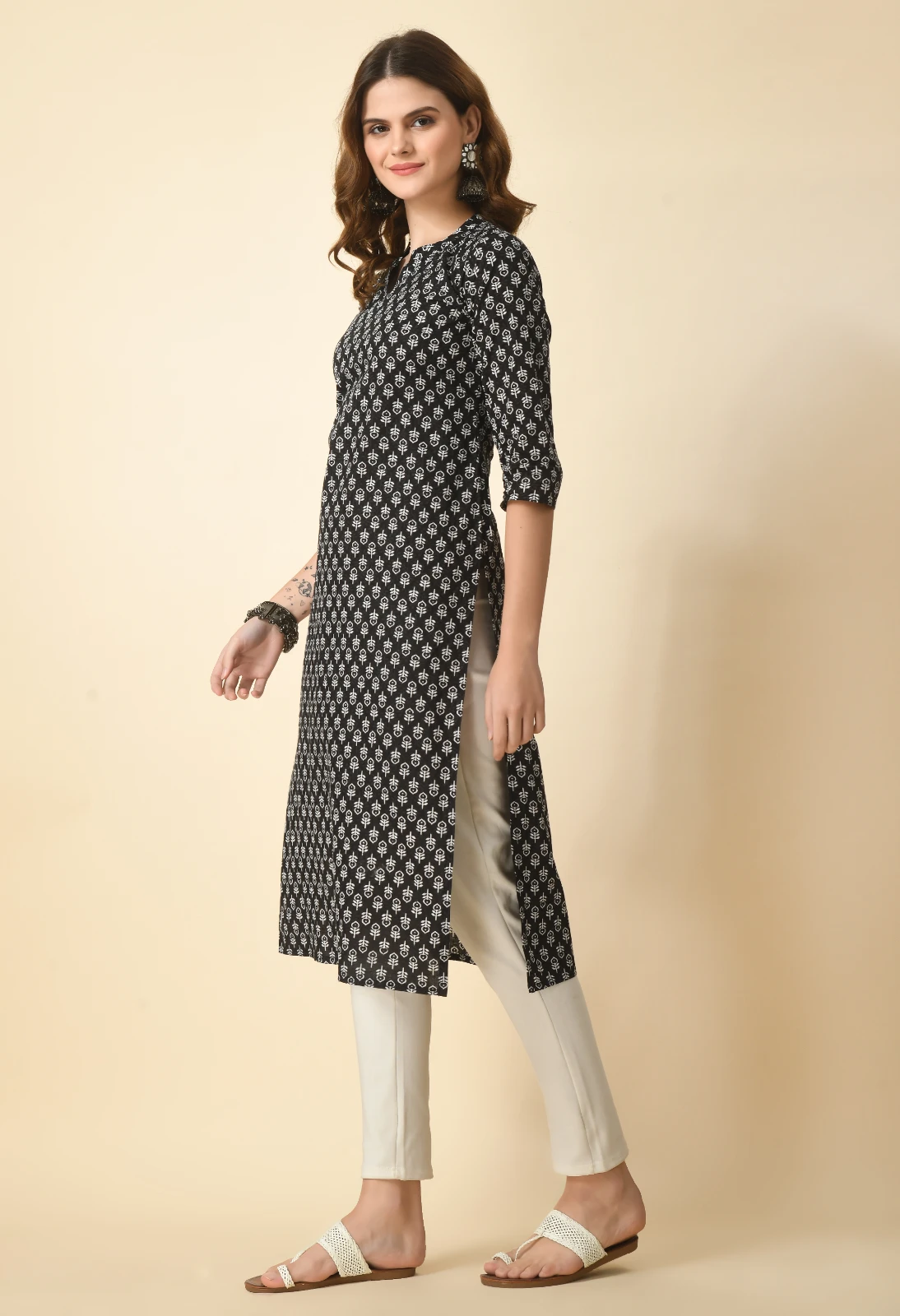 Left side view of black and white printed kurta showing side slit over off-white slim pants