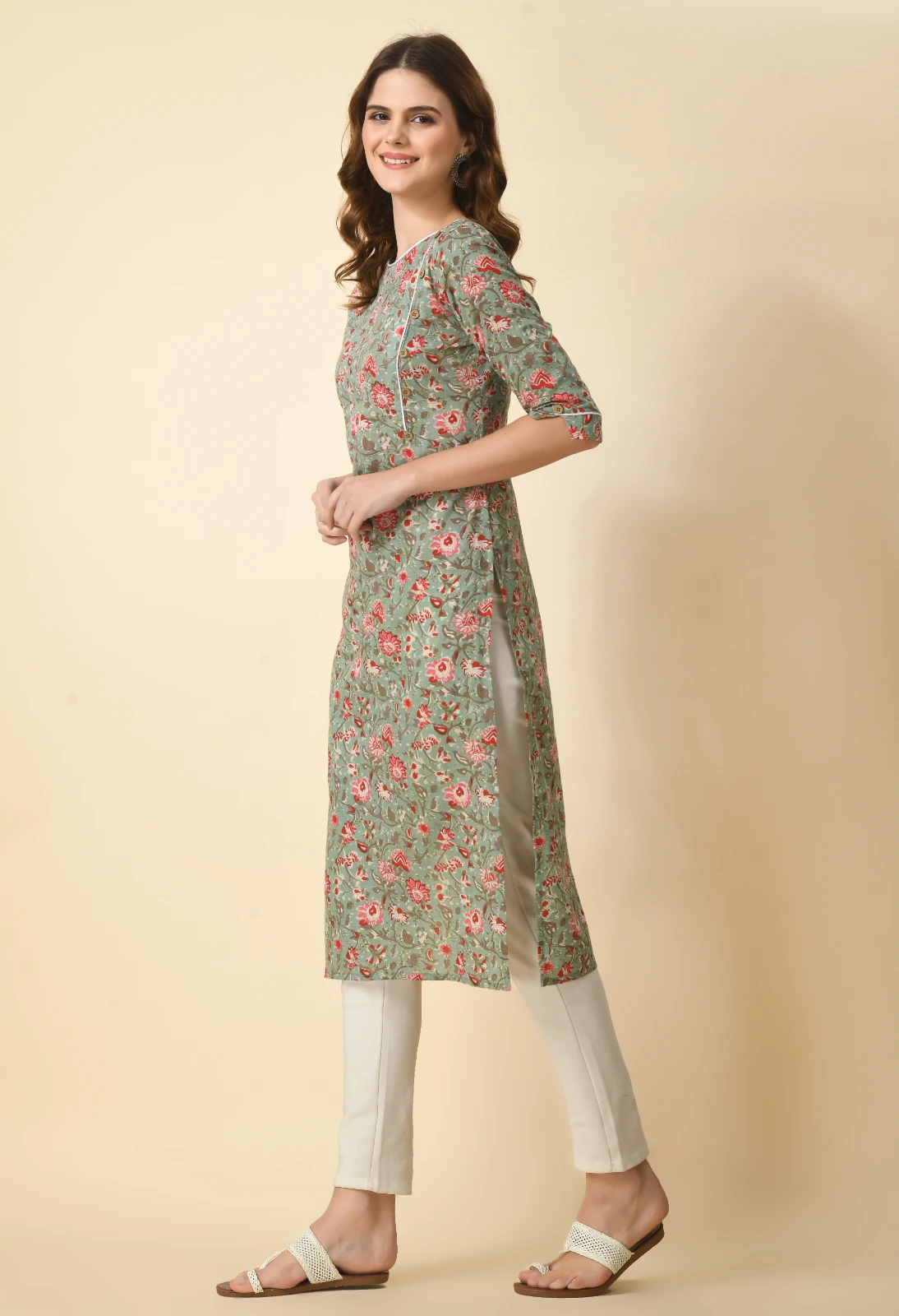 Side view of sage green floral straight kurta showing side slit and contrast piping with white trousers