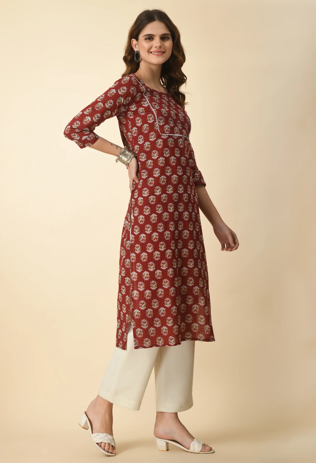Angled front view highlighting the yoke seam and allover floral print on the rust kurta