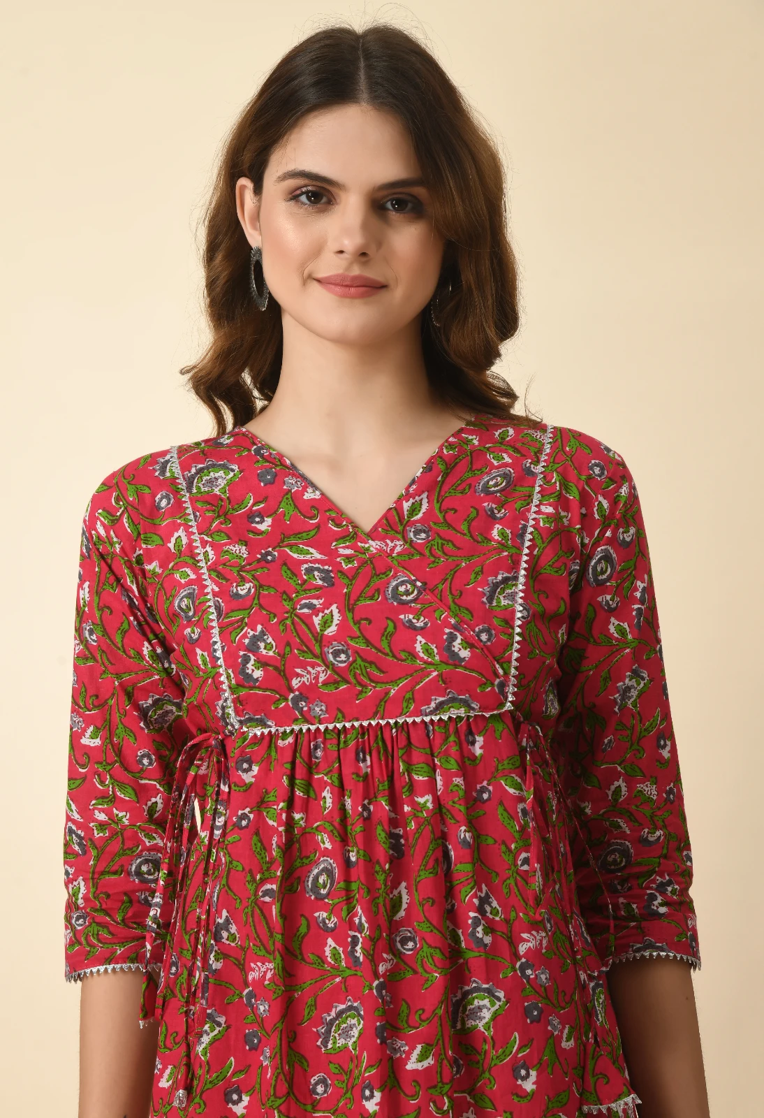 Close-up of the V-neck bodice with contrast piping, gathered empire waist and side tie detail