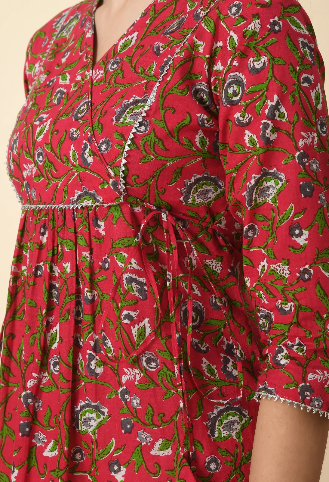 Detail of the floral fabric showing the waist tie, printed sleeve and silver trim edging