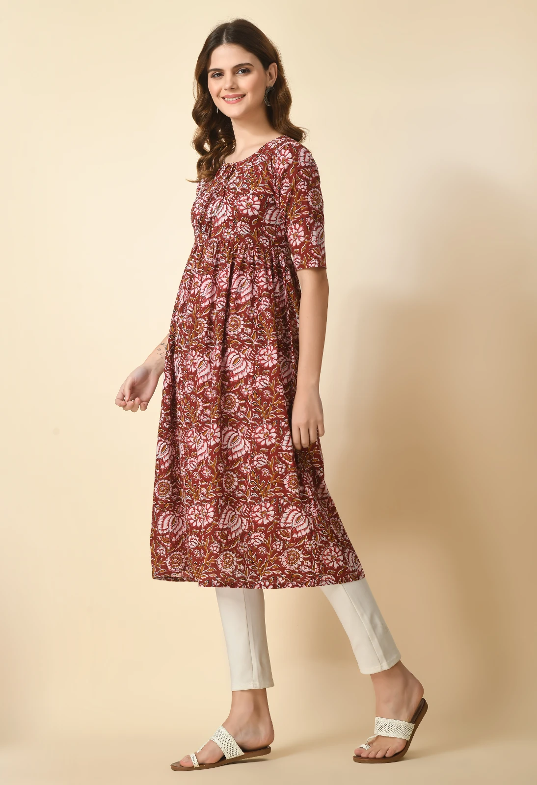 Three-quarter left view of rust floral Anarkali kurta, showing gathered waist and side flare