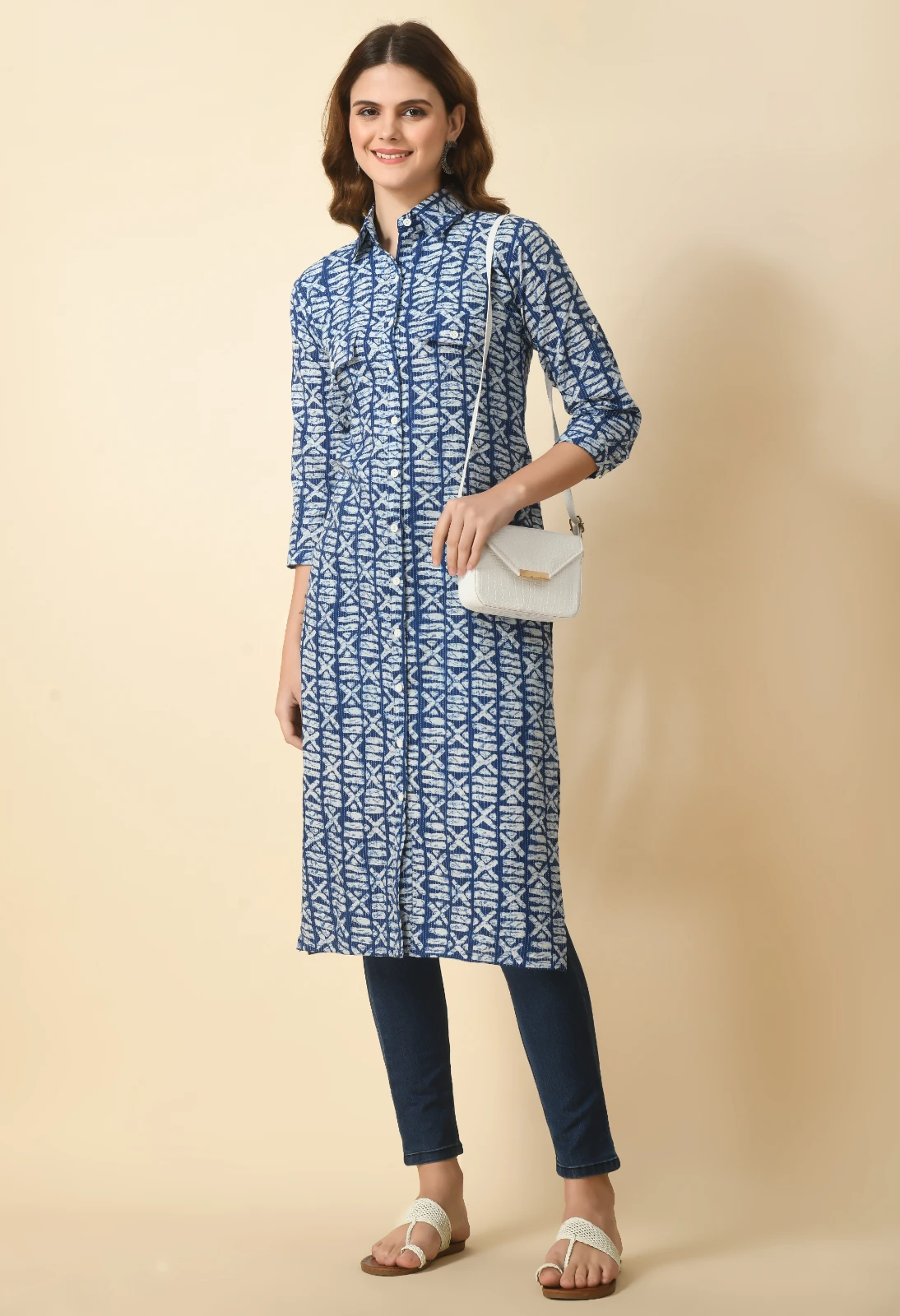 Front view of the printed kurta styled with a white crossbody bag, dark leggings, and flat sandals