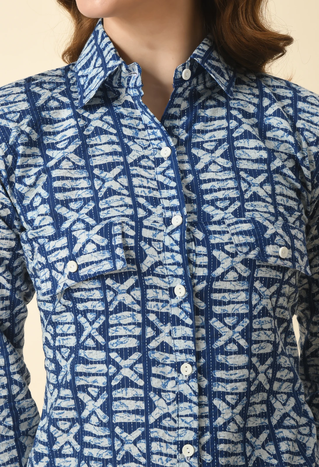Close-up of the kurta's collar, white button placket, and twin flap chest pockets in blue printed fabric