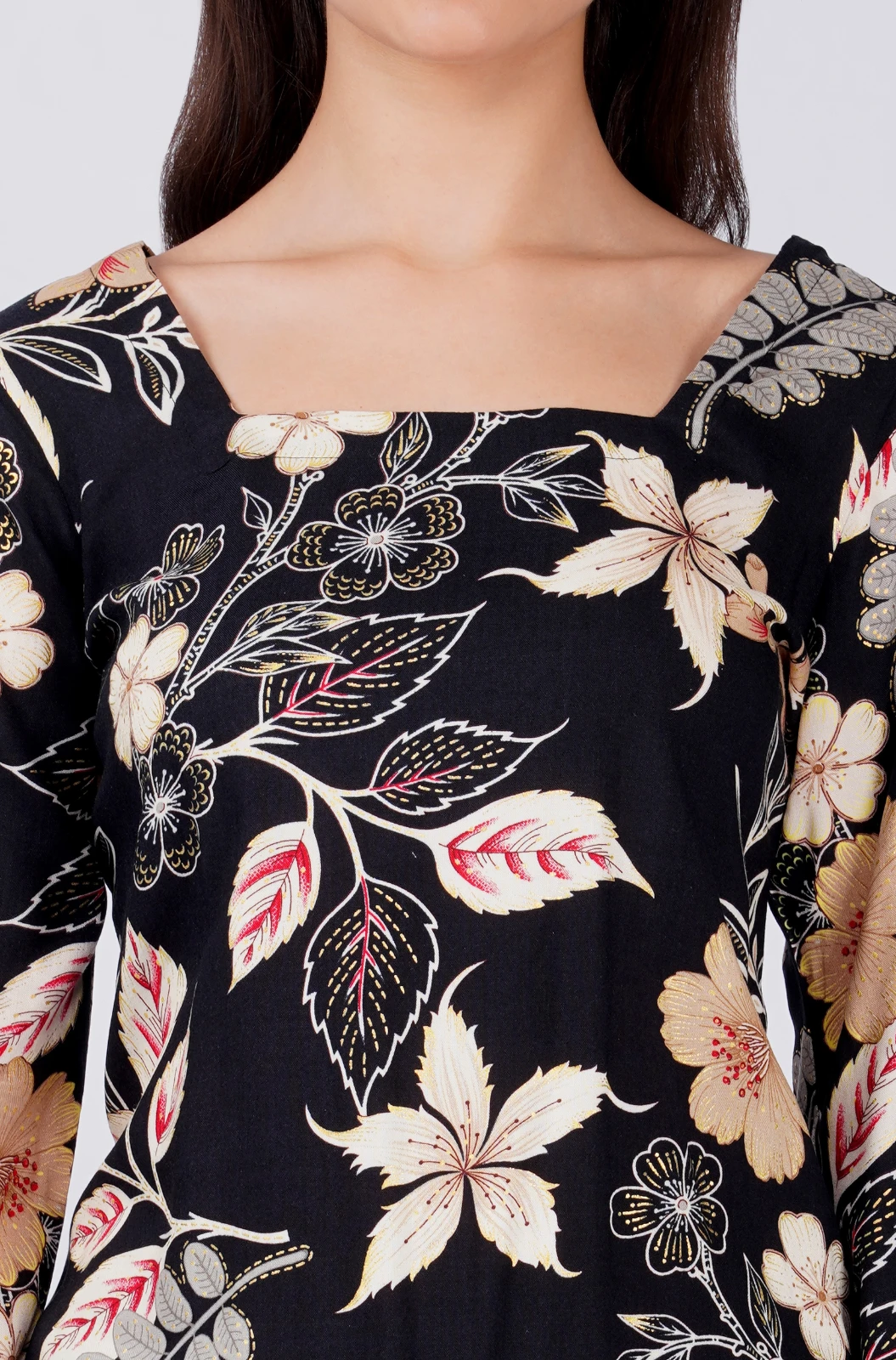 Close-up of square neckline and beige floral print on black fabric