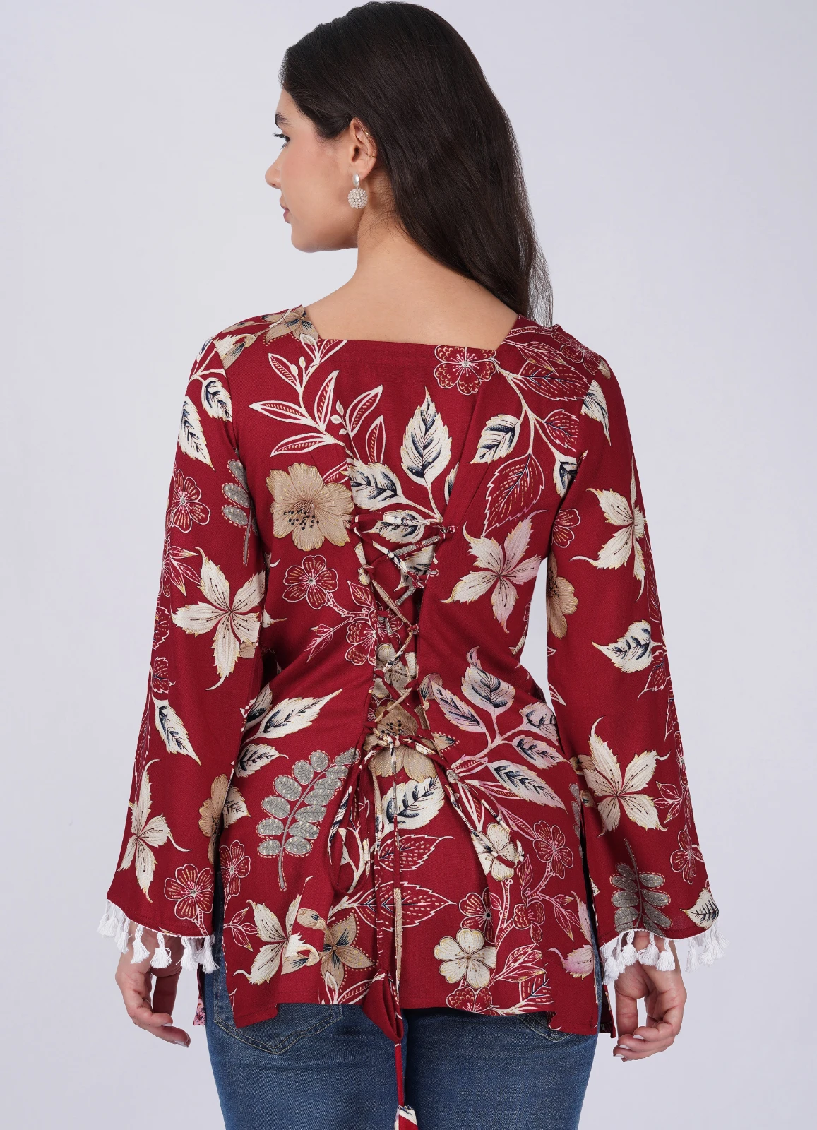 Back view showing lace-up detail on the maroon floral top with long flared sleeves