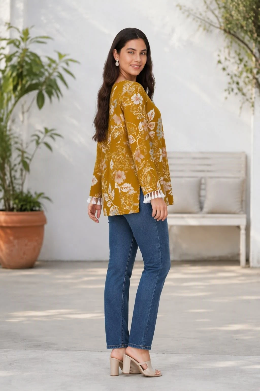 Side angle of the tunic showing hem slit, drape and tassel-trim sleeve edge