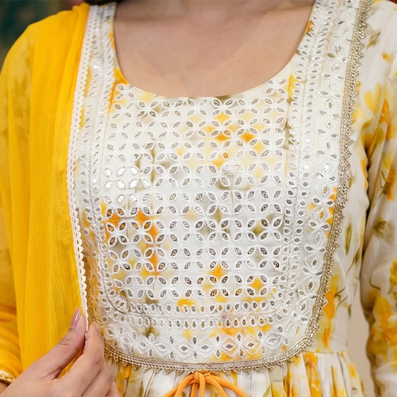 Close-up of square embroidered yoke with mirrorwork, lace trim and floral print bodice with yellow dupatta