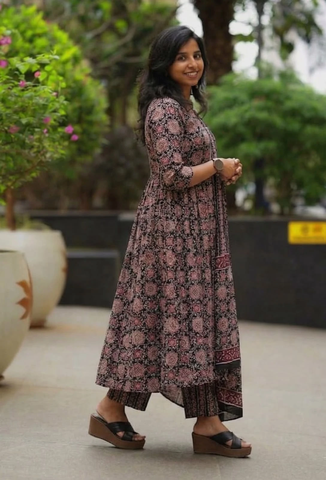 Side profile of the flared kurta with striped pants and contrasting border on the dupatta