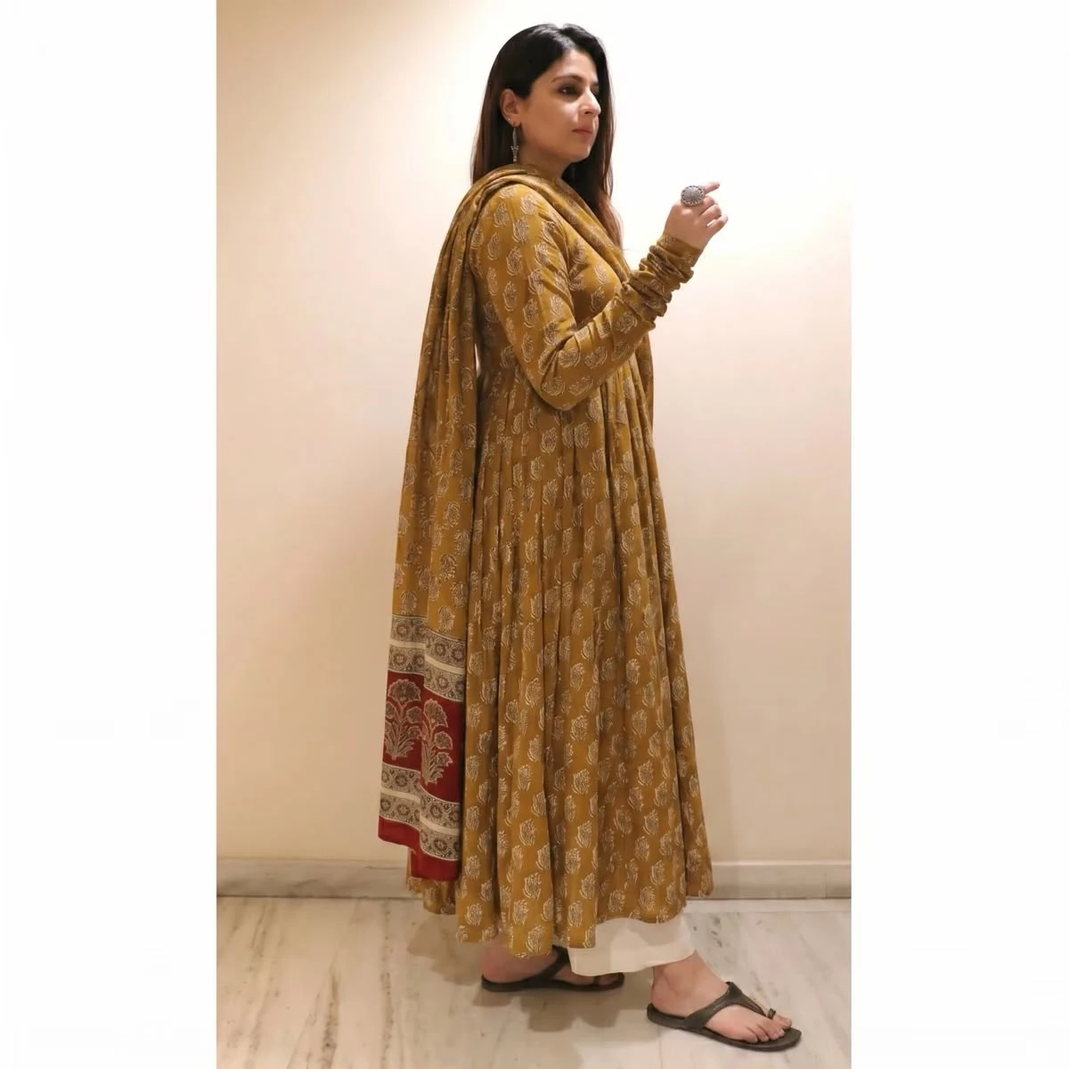Side profile of the mustard ethnic set highlighting the flowy hem and printed dupatta fall