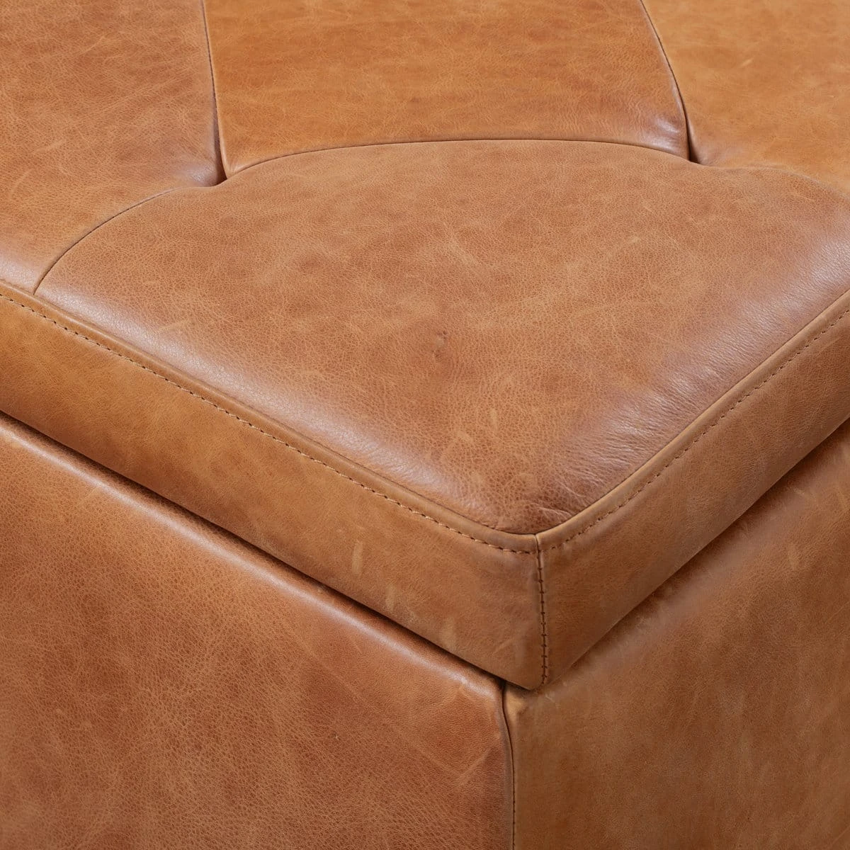Close-up of tufted lid corner with stitched edges and natural full grain leather texture