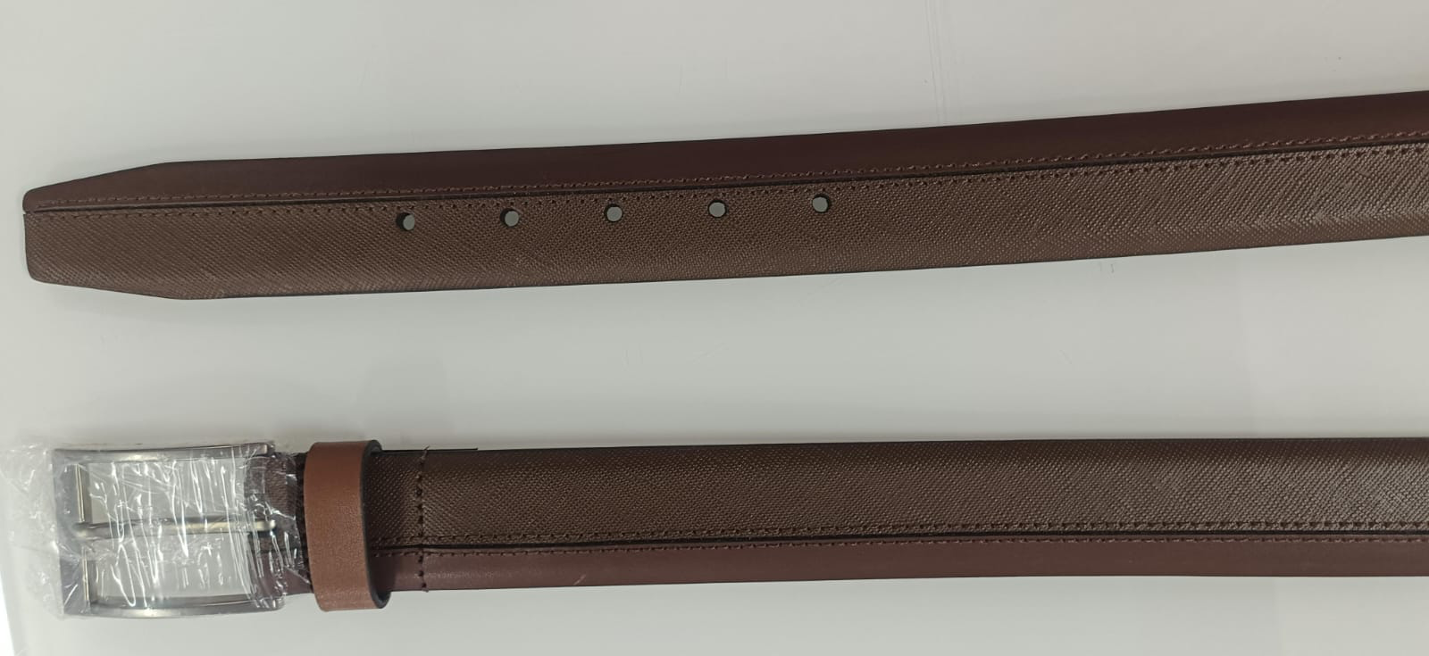 Brown belt coiled flat with smooth strap, keeper loop and shiny gold-tone pin buckle on white background