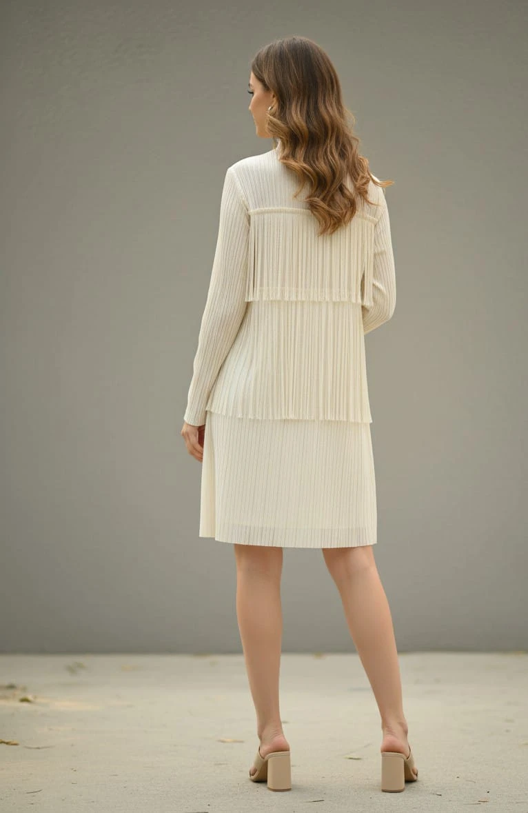 Woman wearing an ivory pleated knee-length long-sleeve dress with beige block-heel sandals