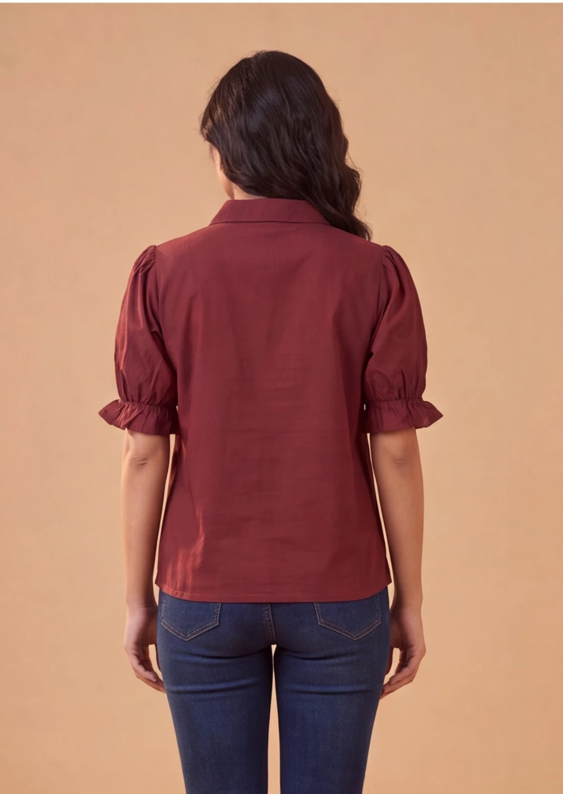Women’s maroon puff sleeve top with collar and white leaf print, paired with blue jeans