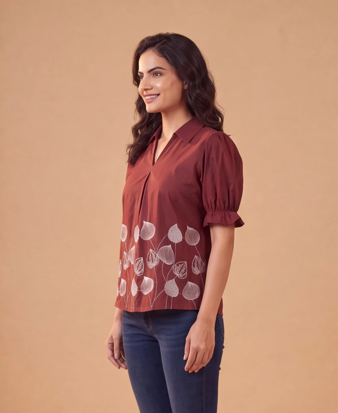 Women’s maroon puff sleeve top with collar and white leaf print, paired with blue jeans