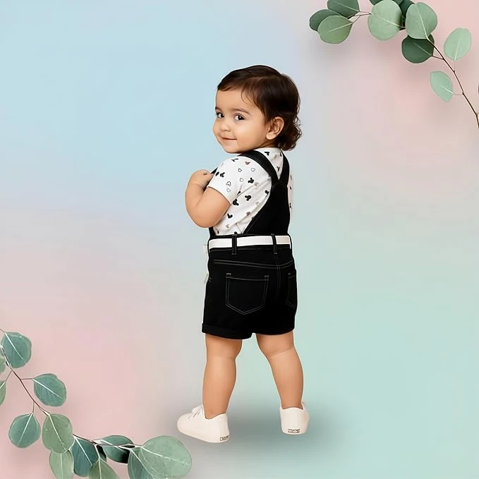 Toddler wearing black dungaree romper with cartoon print over white printed T-shirt and white shoes