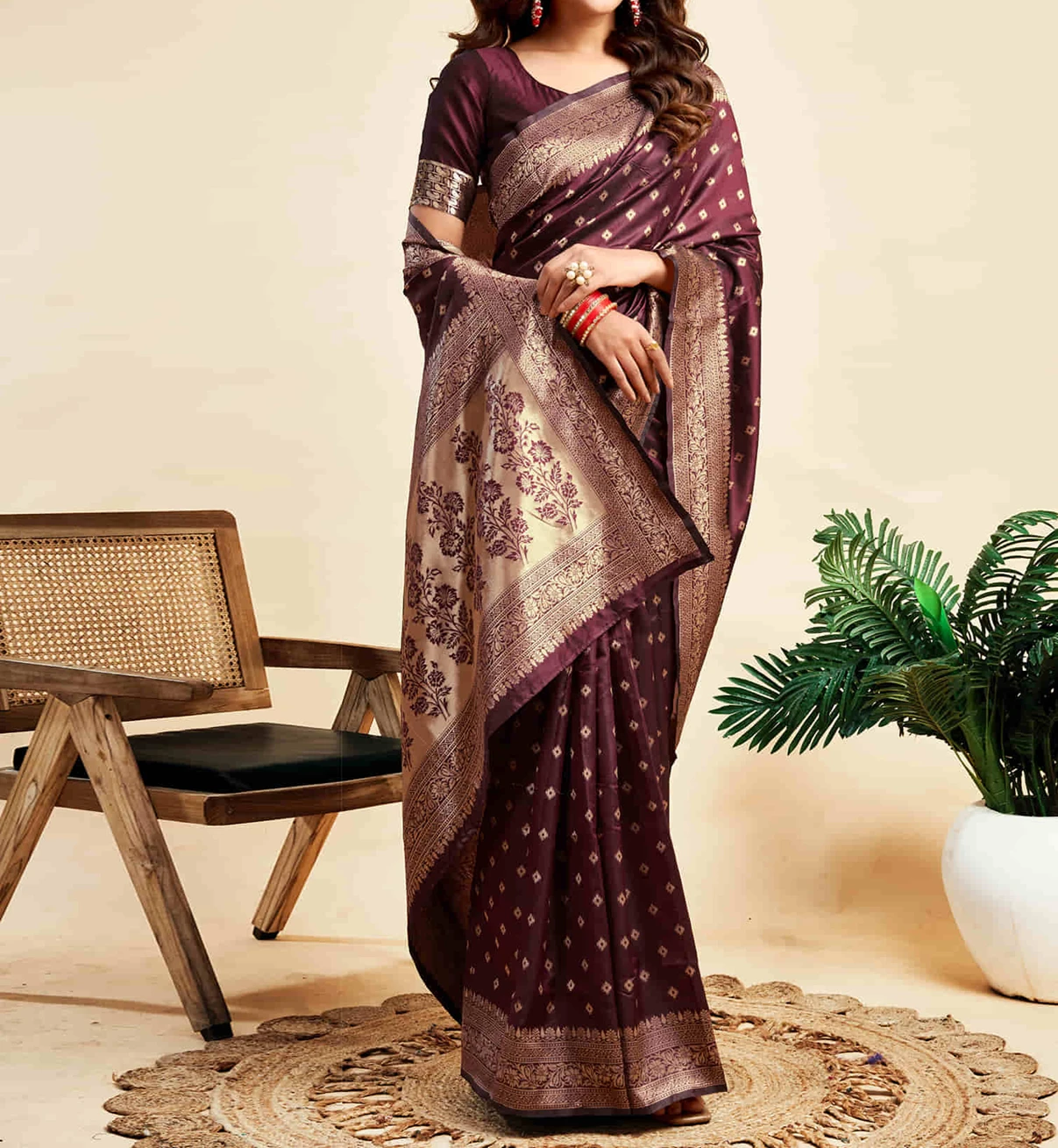 Woman wearing a maroon silk saree with golden zari border and motifs in festive decor