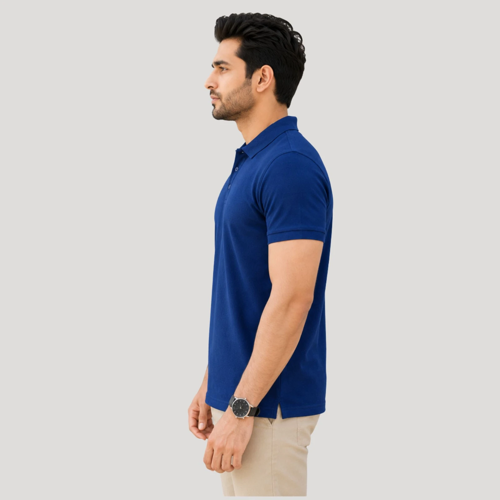 Man wearing a solid blue short-sleeve polo T-shirt with beige trousers