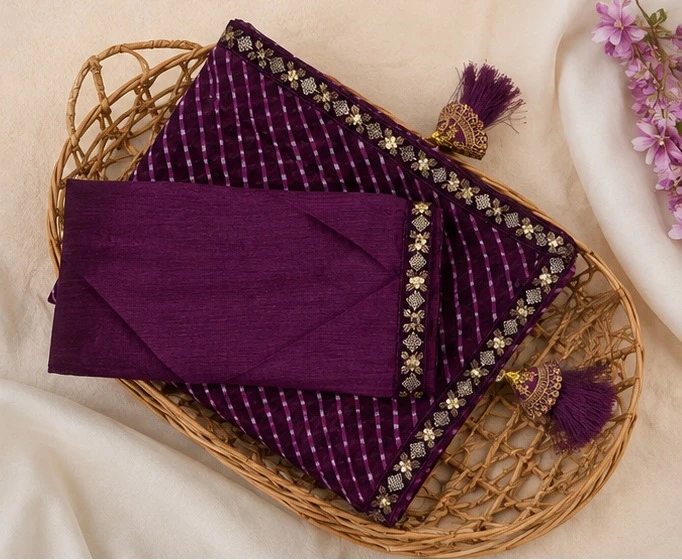 Woman wearing a purple striped saree with gold embroidered border and matching sleeveless blouse