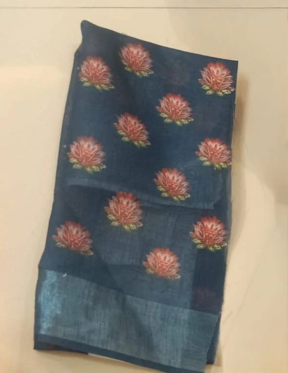 Woman wearing a blue floral printed saree with scenic border and matching blouse