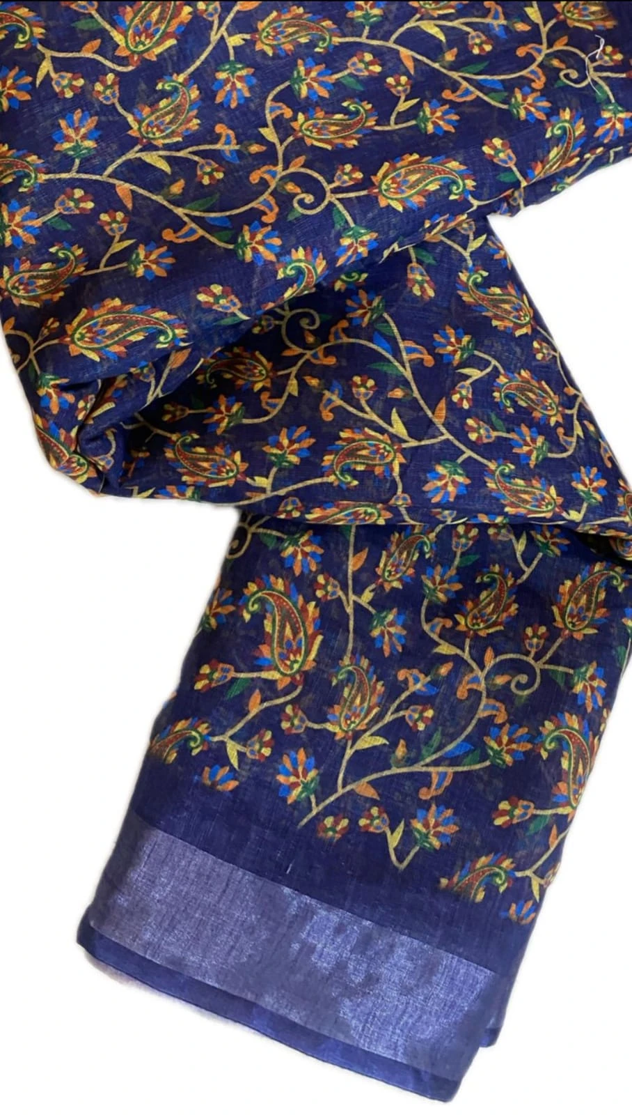 Blue floral and paisley printed saree with matching blouse piece and solid border laid on floor