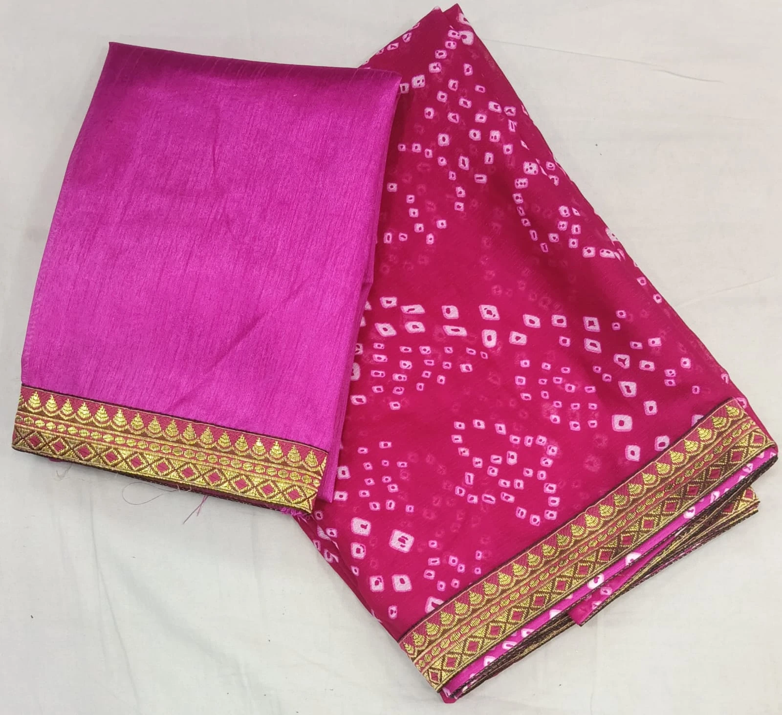 Back view of woman wearing a pink silk saree with gold woven border and matching blouse