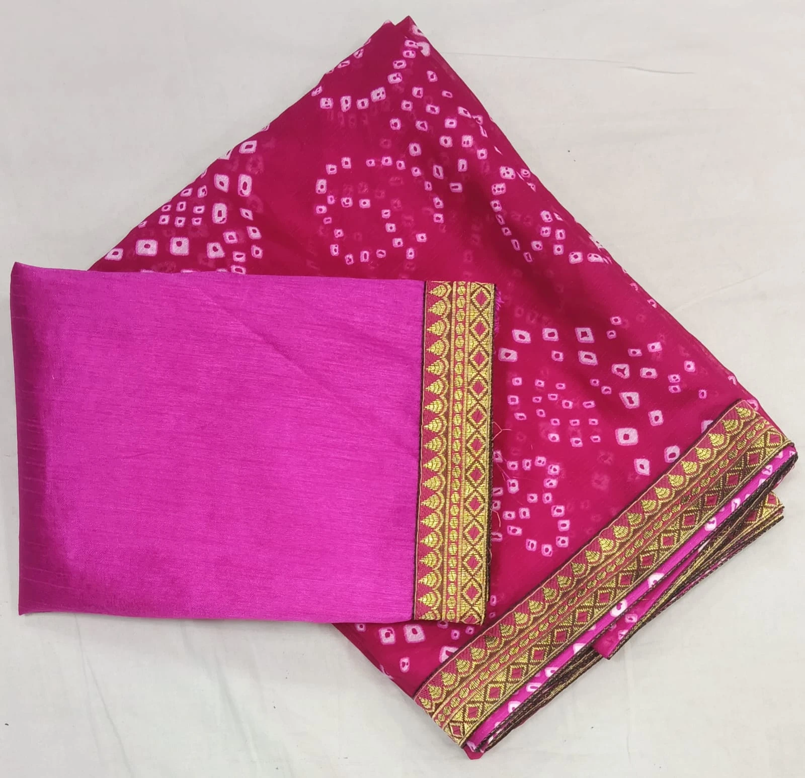Back view of woman wearing a pink silk saree with gold woven border and matching blouse