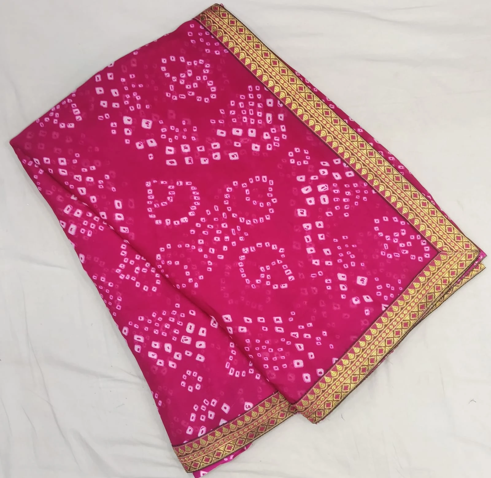 Back view of woman wearing a pink silk saree with gold woven border and matching blouse