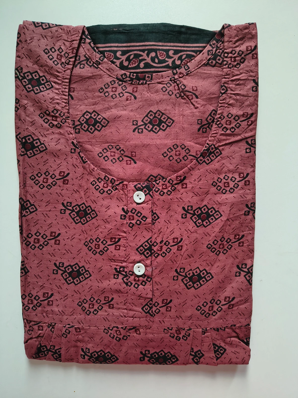 Woman wearing a rust printed full-length nighty with short sleeves and buttoned round neckline