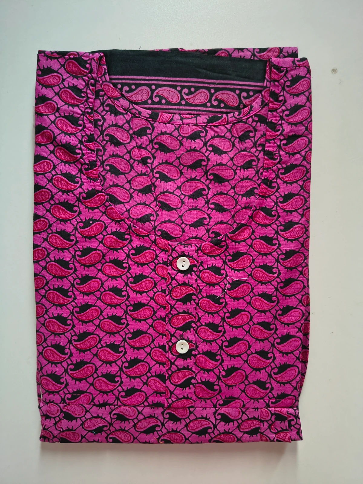 Woman wearing a pink printed full-length nighty with short sleeves and front buttons